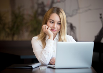 Mulher olhando com dúvidas para a tela de um computador
