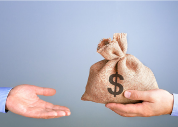 Imagem de uma mão entregando um saco de dinheiro para outra mão