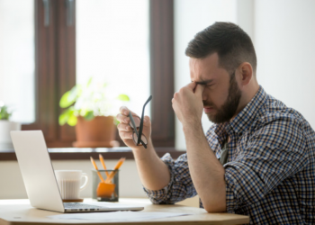 Homem preocupado com a mão nos olhos