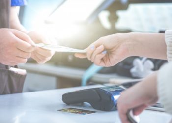 Vendedor passando cartão de cliente em máquina de cartão