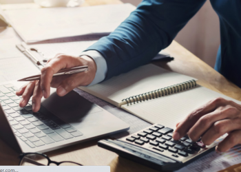 Imagem de uma mão masculina fazendo contas em uma calculadora