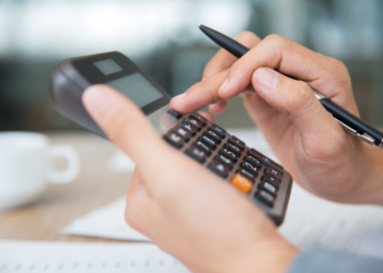 Mão masculina fazendo contas em uma calculadora