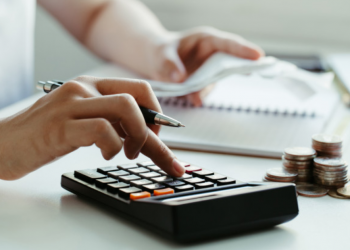 Imagem de uma mão fazendo contas em uma calculadora