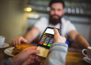 homem passando cartão em uma maquininha